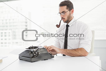 Hipster businessman using a typewriter smoking a pipe