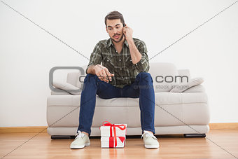 Confused man looking at gifts on floor