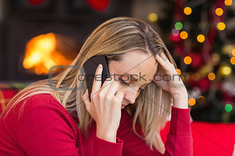 Upset young woman looking down while calling on phone