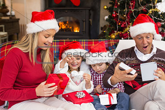 Festive shocked family exchanging gifts