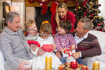 Multi generation family opening presents on sofa