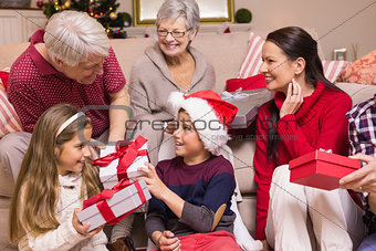 Multi generation family exchanging presents on sofa