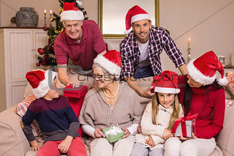 Happy extended family in santa hat holding gifts