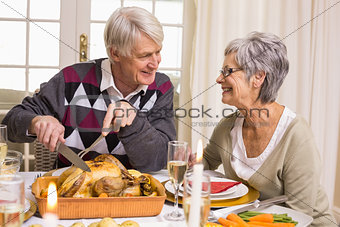 Grandfather carving roast turkey at christmas dinner