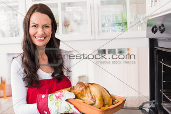 Smiling woman holding roast turkey