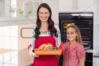Surprised mother and daughter posing with roast turkey