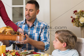 Woman passing the roast turkey to her husband