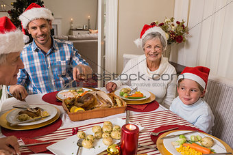 Father in santa hat serving roast turkey at christmas