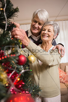 Senior couple decorating their christmas tree