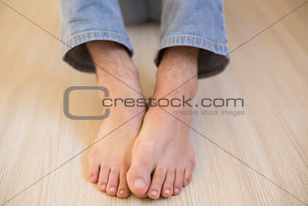 Mans bare feet on wooden floor