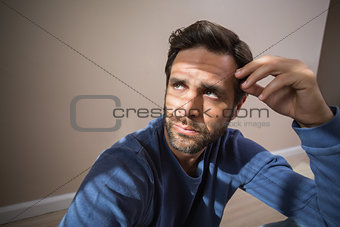Depressed man sitting on floor