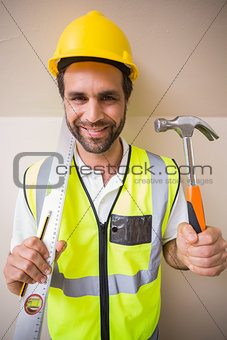 Construction worker holding spirit level and hammer