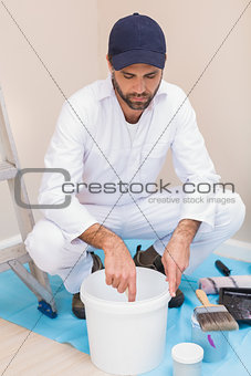 Painter mixing paint in a bucket