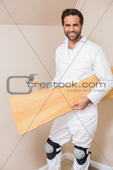 Carpenter holding planks and hammer