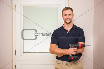 Construction worker holding power tool with arms crossed
