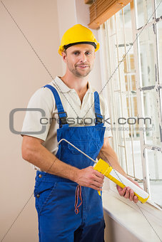 Man putting filling between window and wall