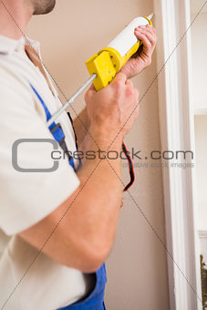 Man putting filling between door and wall