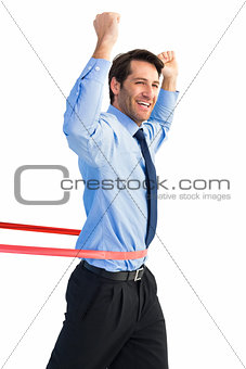 Happy businessman crossing finishing line