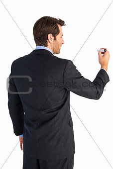 Businessman standing back to camera writing with marker