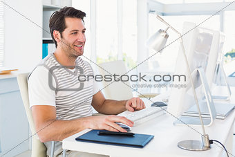 Smiling casual young man using computer