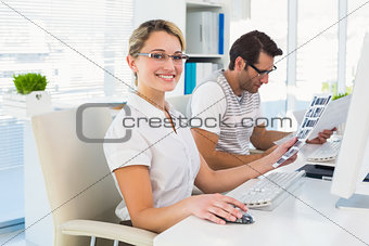 Photo editor holding contact sheet and smiling at camera
