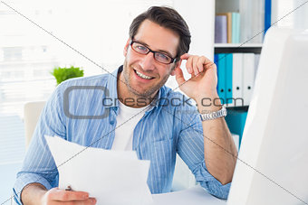Smiling photo editor at work holding contact sheet