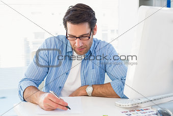 Photo editor writing on a paper