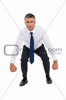 Businessman bending and clenching fists