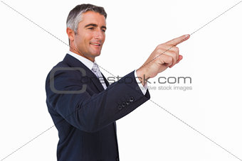 Smiling businessman in suit pointing