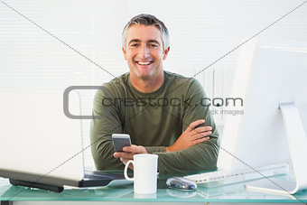Smiling man holding his mobile phone