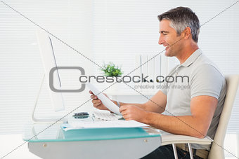 Happy man reading document at desk