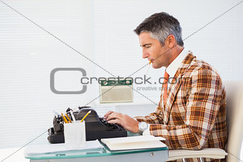 Retro man with cigarette typing on typewriter