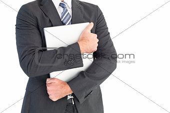 Businessman holding his laptop tightly