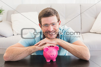 Smiling man with a piggy bank