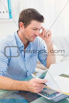 Businessman reading document at his desk in his office