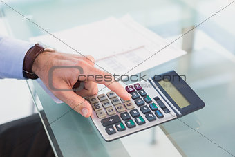 Businessman pushing key on calculator