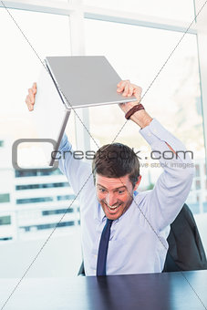 Angry businessman throwing his laptop