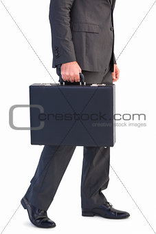 Businessman holding briefcase walking
