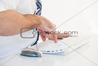 Mid section of businessman using computer keyboard