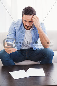 Worried man holding his phone
