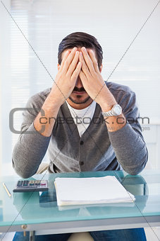 Worried businessman with head in hands