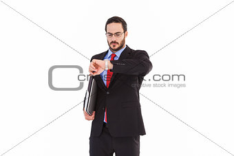 Frowning young businessman checking time
