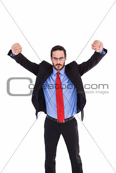 Unsmiling businessman standing with arms raised
