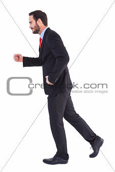 Smiling businessman stepping with hands raised