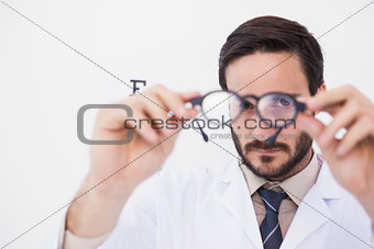 Doctor wearing lab coat looking through eyeglasses