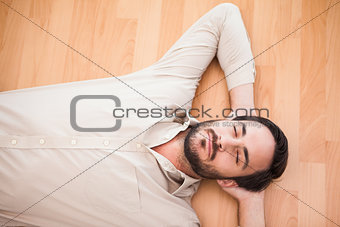 Young man lying on floor thinking