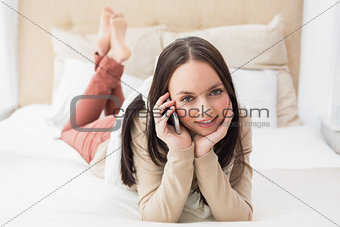 Pretty brunette making a call on bed