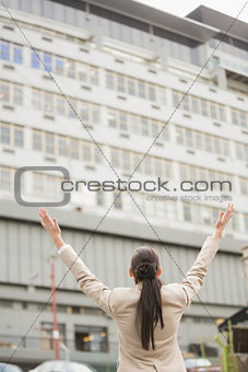 Young businesswoman with her arms up