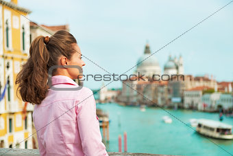 Young woman looking into distance while standing on bridge with 