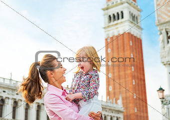 Portrait of smiling mother and baby against campanile di san mar